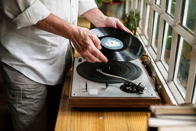 Hands inserting a vinyl disc into the player
